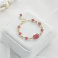 Elegante aardbeienkwartskristallen armband met gouden Piyao-bedel op wit fluweel - Aardbeienkwarts Pixiu Gouden Kraal Armband