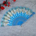 Primer plano de un abanico plegable azul con motivos de mariposas doradas. - Sin Borla / Azul cielo