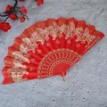 Vista detallada de un abanico chino rojo con elegantes patrones de mariposas doradas - Diseño de Rosa / Rojo