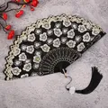 Detailed shot of traditional Chinese folding fan with black gold floral embroidery and tassel. - Black Cherry Blossom Fans with Large Tassels