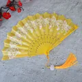 Detalle del abanico plegable amarillo con motivos de mariposas y una borla decorativa - Con borlas / Amarillo