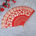 Detailansicht eines roten chinesischen Faltfächers mit eleganten weißen Blumenmustern - Einzelfächer / Rot