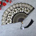Elegante abanico chino plegable negro con motivos florales blancos y borla negra. - Con Borla / Negro
