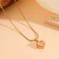 Gedetailleerde close-up van gouden ketting met een roze kristallen hart hanger. - Goud Roze Diamant Ketting