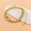 Vue détaillée d'un bracelet en maille gourmette avec breloque cœur en acier inoxydable doré. - Bracelet (B703) / Bracelet Uniquement