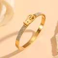 Close-up of elegant gold stainless steel bangle featuring crystal inlaid belt buckle design. - 金色皮带扣镶钻款(H322)