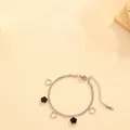 Detailed view of silver stainless steel bracelet featuring black and hollow flower charms. - Black Shell Steel Five-Petal Flower Bracelet (T210)
