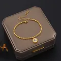 Close-up of a gold-plated stainless steel beaded bracelet with a Roman numeral pendant. - White Rhinestone Bead Bracelet (A814)