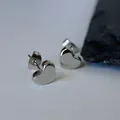 Close-up of silver heart-shaped stud earrings in titanium steel with polished finish. - 耳钉G305 / Silver