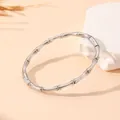 Détail d'un bracelet jonc en acier inoxydable à motif bambou argenté sur pierre. - Bambou Fermoir Invisible (S102) / Acier