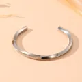 Gros plan sur un bracelet jonc torsadé en acier inoxydable argenté minimaliste - Style Mobius Torsadé (S506) / Acier