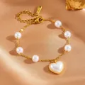 Elegant close-up of gold stainless steel bracelet with white pearls and heart pendant - Pearl Heart
