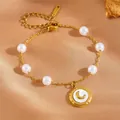 Elegant gold stainless steel bracelet with white pearls and a crescent moon charm - White Shell Moon