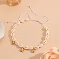 Detail view of shell necklace with golden dolphin and starfish charms on adjustable string - Starfish Shell Necklace / Off White
