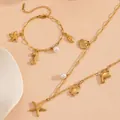 Close-up detail van vergulde oceaan thema sieradenset met zeester en parel hangers. - Strand sieradensets met zeester en strass