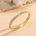 Detailopname van gouden titanium stalen hartarmband met glinsterende micro-pave strassteentjes. - Iced Out Hart Stijl / Goud