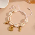 Close-up detail of natural shell bracelet with golden seahorse and shell charms - Conch Bracelet / White