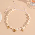 Detailed macro view of cowrie shell necklace with dolphin, fish and turtle charms - Small Fish Necklace / White