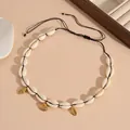 Close-up detail view of a natural white seashell necklace with golden shell pendants. - Black Rope Shell Necklace