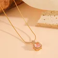 Gedetailleerde macrofoto van een zeshoekige gouden hanger met roze kristalsteen - Ketting / Goud Roze Diamant Ketting