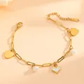 Gedetailleerd close-up van een gouden titanium stalen armband met hartjes en parels - Hart Parel Stijl (E415) / Goud