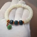 Detailed view of a white bodhi root bead bracelet featuring a green lotus seed pod charm. - Lotus Seed Pod Style / White