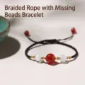 Handcrafted braided black rope bracelet featuring a central red agate and cat-eye beads. - Braided Cord Transfer Bead Gold Thread Bracelet / Single Bracelet