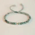 Macro view of a handmade green moss agate bracelet featuring a gold accent bead. - 4mm Bead - Single Gold Bead / Summer Moss Green with Single Gold Bead