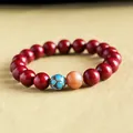 Elegant red cinnabar beaded bracelet featuring a blue cloisonné bead and a peach sunstone accent - Purple Gold Cinnabar Style (Copper) / 10mm