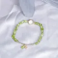 Elegant peridot beaded bracelet with star charm and white stone on silk - Peridot