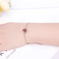 Elegant gold-plated chain bracelet featuring a round strawberry crystal on the wrist. - Strawberry Quartz