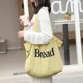 Elegante geel gestreepte canvas draagtas met Bread-opdruk gedragen door een model - Geel