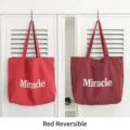 Reversible red nylon tote bag with white Miracle print and subtle plaid pattern texture - Red Reversible