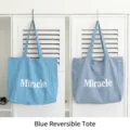 Blue reversible nylon tote bag with white Miracle print on both sides of the bag - Blue Reversible