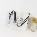 Primer plano del bolso de lona blanco con el estampado artístico 'We Run Together' - Estilo de Correa a Rayas con Gráfico Creativo (SR4012)