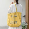 Grote gele canvas draagtas met blauwe "STOW IT HERE" letteropdruk voor dames. - Geel