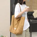 Classic brown polka dot canvas tote bag in Japanese literary style worn by a fashion model - Brown