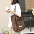 Minimalist Japanese style brown canvas tote bag featuring white polka dots on model - Coffee