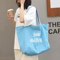 Light blue canvas tote bag featuring white 'just chillig' text print and striped strap - just chilling Letter Style / Light Blue