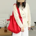 Vibrant red suede drawstring tote bag featuring stylish pleated design and soft texture - Red