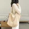 Casual Japanese style corduroy drawstring tote bag in beige shown on a model's shoulder - Apricot