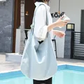 Large light blue casual canvas shoulder bag shown on a model at a poolside cafe - Knot Decoration Large Style (SR2858) / Blue