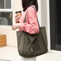 Bolso de lona verde oliva informal con estampado gráfico Paws Chill sostenido por mujer. - Estilo de Lona con Estampado Paws Chill (SR5555)