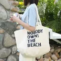 Bolso de lona blanco roto informal con el estampado de NOBODY OWNS THE BEACH - Estilo con Estampado de Letras Artísticas (SR7184)