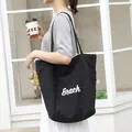 Casual black nylon tote bag featuring a stylish white 'Beach' lettering print for women - Black