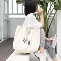 Bolso tote casual de lona blanca para mujer con un diseño minimalista de letras azules - Estilo de Bolsillo con Decoración de Letras (SR1079)