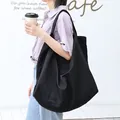 Grote zwarte waterdichte nylon draagtas voor dames gedragen in een café-omgeving - Zwart