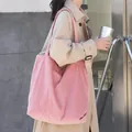 Stylish large pink corduroy tote bag with vertical texture shown on model's shoulder. - Pink