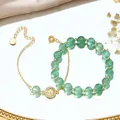 Detailed close-up of green crystal beaded bracelet with intricate gold Tree of Life - Green Strawberry Quartz Set