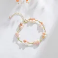 Elegant freshwater pearl floral bracelet with gold-tone links on white linen backdrop. - Pearl Copper Tube Woven Style